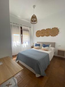 a bedroom with a large bed with a blue blanket at Habitaciones Carmencita in Bolonia