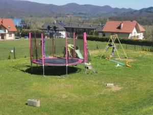 a group of kids playing on a trampoline in a field at BUENA VISTA POLAŃCZYK domki z klimatyzacją 506 - 289 - 019 in Polańczyk