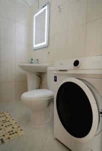 a washing machine in a bathroom with a toilet and a sink at Villa Apartments S&F City Centre in Tirana