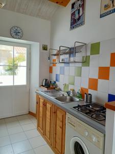 eine Küche mit Spüle und Waschmaschine in der Unterkunft La Maison du Marin in Saint-Gilles-Croix-de-Vie