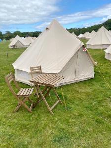 ein Zelt mit einem Stuhl und einem Tisch auf einem Feld in der Unterkunft IntentsGP @ Isle of Man TT, IOMTT in Douglas
