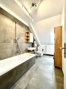 y baño con bañera y lavamanos. en Zentral gelegene DG-Wohnung mit 4 Schlafzimmern, en Eisenach