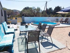 une terrasse avec une table, des chaises et une piscine dans l'établissement EnjoyRhodes Villa near Faliraki, à Kalithies