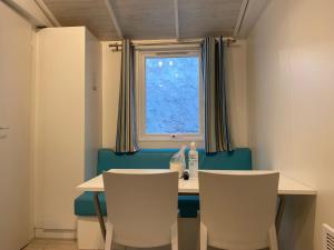 a dining room with a table and chairs and a window at Mobile home Premium 24m² 2 chambres in Arès