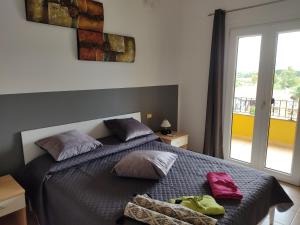 ein Schlafzimmer mit einem Bett mit zwei Kissen und einem Fenster in der Unterkunft Casa Vacanze - Villa San Pietro in Villa San Pietro