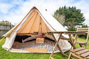 ein Tipi-Zelt mit einem Bett und einem Stuhl in der Unterkunft IntentsGP @ Isle of Man TT, IOMTT in Douglas