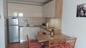 a kitchen with a table and a refrigerator at Apartments Nikola Caska in Novalja
