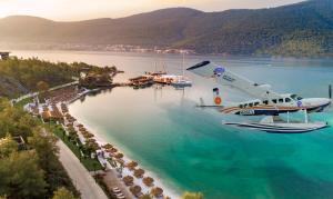 a plane flying over a beach in the water at Lujo Hotel Bodrum in Guvercinlik +210 photos