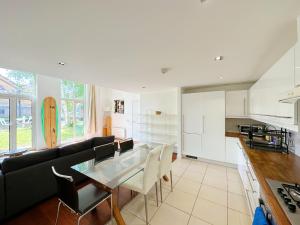 a kitchen and living room with a glass table at Portobello Dock Canalside Apartment in London