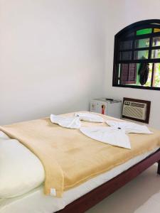 uma cama num quarto com uma janela em Pousada Paraiso do Sol em Saquarema