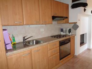 Menzonio的住宿－Lucciola 1，一个带木制橱柜和水槽的厨房