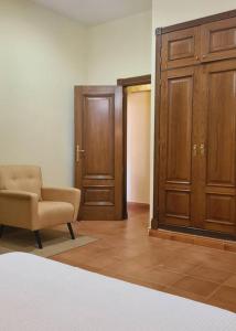 a room with a bed and a chair and a closet at Acogedora Suite con entrada independiente in El Puerto de Santa María