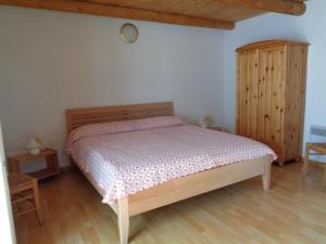a bedroom with a bed and a wooden cabinet at Lucciola 1 in Menzonio