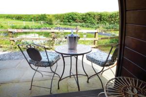 a patio with a table and two chairs on a porch at Ocean View 6 - 1 Bed Large Bridal - Llanrhidian in Llanrhidian