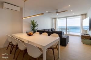a dining room and living room with a table and chairs at Vista Roses Mar - El Brancs in Roses