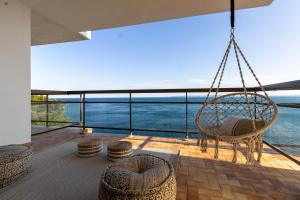 a swinging chair on a balcony with a view of the ocean at Vista Roses Mar - El Brancs in Roses