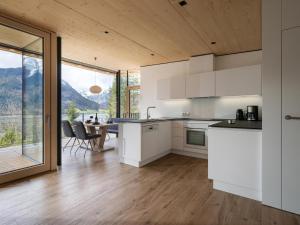 a kitchen with white cabinets and a table with chairs at Ferienwohnung Auszeit am See in Achensee