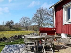 a wooden table and chairs next to a red building at 5 person holiday home in Brösarp-By Traum in Brösarp +18 photos