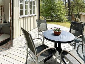 patio ze stołem i krzesłami na tarasie w obiekcie Holiday home SÖLVESBORG XVI w mieście Sölvesborg