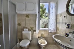 a bathroom with a toilet and a sink and a window at Mamaamelia in Levanto