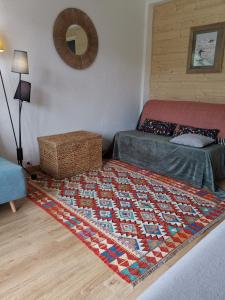 1 dormitorio con cama y alfombra en el suelo en Alpazur-studio départ pistes, en Péone