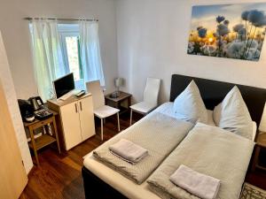 a bedroom with a bed and a desk with a computer at Pension Steakhaus Füssen in Füssen