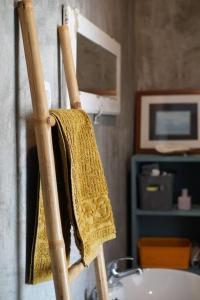een gele handdoek op een ladder naast een wastafel bij Vila Amarilis in Luz de Tavira