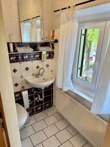 a bathroom with a sink and a toilet and a window at Pension Steakhaus Füssen in Füssen