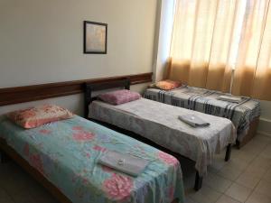 Habitación con 2 camas y ventana en Hotel Minas Salvador en Salvador