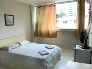 1 dormitorio con cama y ventana en Hotel Minas Salvador, en Salvador