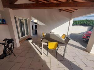 une terrasse avec une table, des chaises et un parasol dans l'établissement Studio neuf avec acces piscine, à Valergues