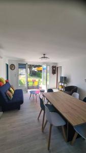 a living room with a wooden table and chairs at Maison 50 m de la plage Valentin in Batz-sur-Mer
