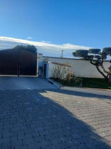 a brick driveway in front of a house at Studio neuf avec acces piscine in Valergues