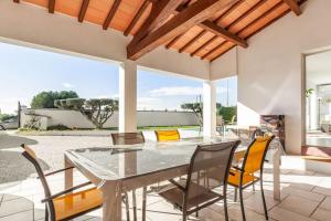 une salle à manger avec une table et des chaises en verre dans l'établissement Studio neuf avec acces piscine, à Valergues