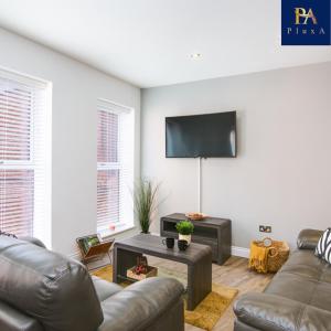 a living room with a couch and a flat screen tv at Pluxa The Hideaway - Fully private serviced apartment & parking in Birmingham