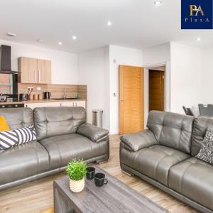 a living room with two leather couches and a table at Pluxa The Hideaway - Fully private serviced apartment & parking in Birmingham