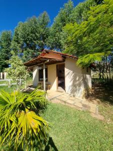 a small house in the middle of a yard at Chalés Encantos da Serra in Carrancas