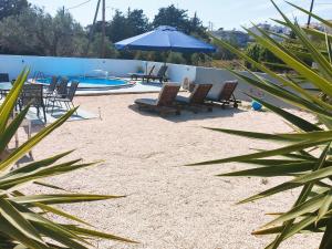 - une plage avec des chaises, un parasol et une piscine dans l'établissement EnjoyRhodes Villa near Faliraki, à Kalithies