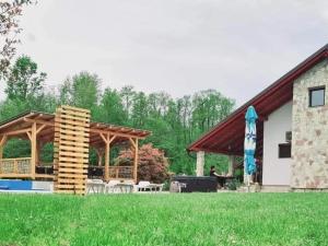 a pavilion with a table and chairs in a yard at Srce Kozare in Prijedor
