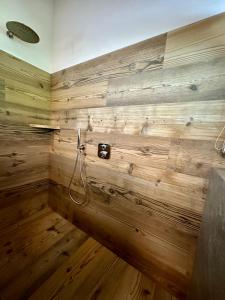 Łazienka z drewnianą ścianą i prysznicem w obiekcie Alpine Escape 1 w mieście Bormio