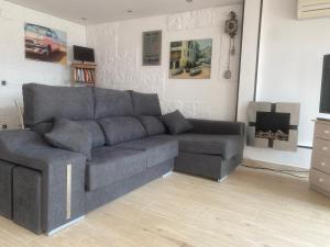 sala de estar con sofá gris y TV en Tossa de mar Amplio Apartamento con vistas al mar, en Tossa de Mar