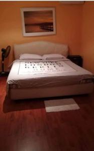 ein großes Bett in einem Schlafzimmer mit Holzboden in der Unterkunft Duxplex aux Portes Monaco in Beausoleil