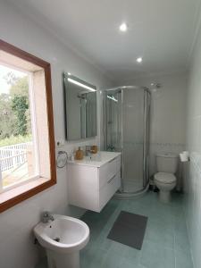 La salle de bains est pourvue de toilettes, d'une douche et d'un lavabo. dans l'établissement Casa playa america Nigrán, à Nigrán
