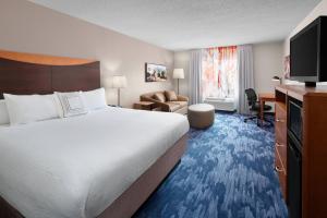 Fairfield Inn & Suites Denver Airport في دنفر: غرفة الفندق بسرير كبير ومكتب