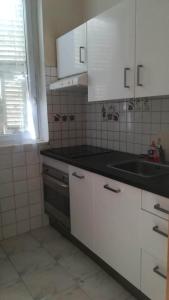 eine Küche mit weißen Schränken und einem Waschbecken in der Unterkunft Duxplex aux Portes Monaco in Beausoleil
