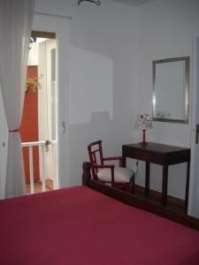 a bedroom with a bed and a table and a chair at B&B Il Gatto Pescatore in Stintino