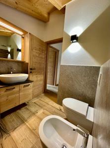 W łazience znajduje się umywalka, toaleta i lustro. w obiekcie Alpine Escape 1 w mieście Bormio