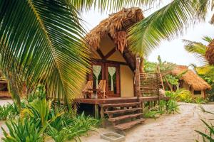 a small house on the beach with palm trees at Ikal Tulum Hotel in Tulum