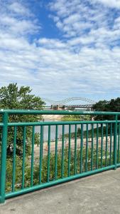 a green metal fence with a bridge in the background at Luxury loft in the heart of downtown Memphis in Memphis