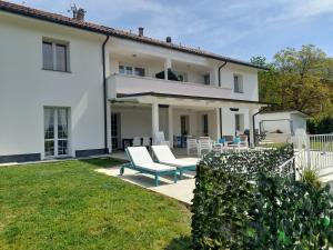 a white house with a patio and lawn at TerrazzaPonente in Monte San Pietro